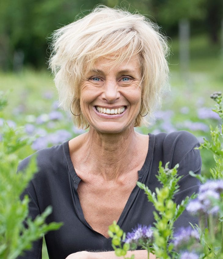 kvinna sitter på blomsterfält