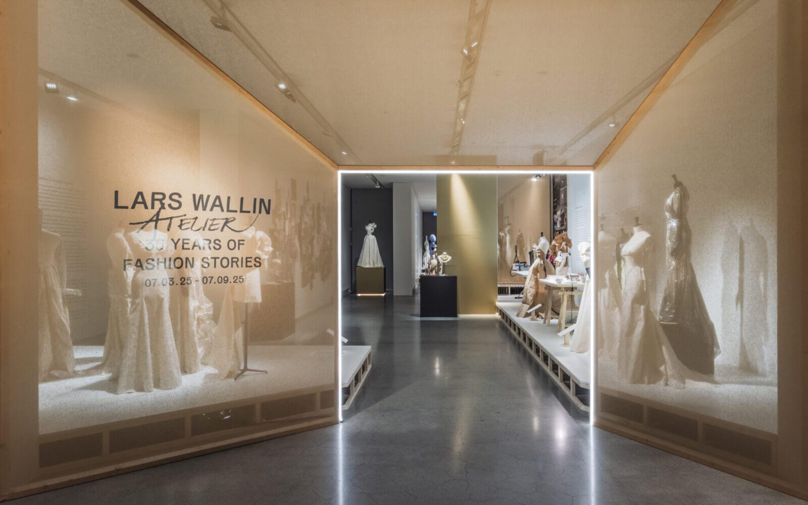 Entré till utställningen "Lars Wallin – 30 år av modehistorier", där eleganta klänningar på skyltdockor visas upp i ett väl upplyst galleri. Upplev tjusningen och kreativiteten i denna kollektion under Artipelagkvällar – Upplev Artipelag kvällstid för en förtrollande kvällsutforskning.