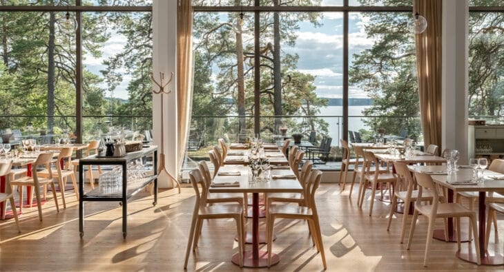 Uppdukade långbord i Artipelag Restaurang med utsikt över Baggensfjärden.