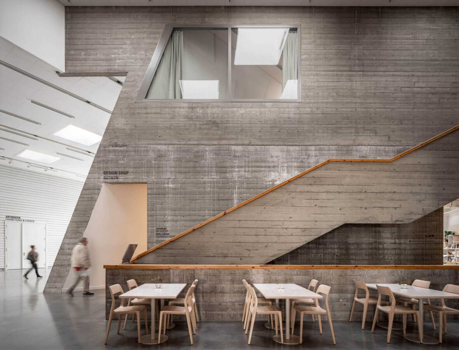 en modern inomhuslokal med stora betongväggar och en trappa.