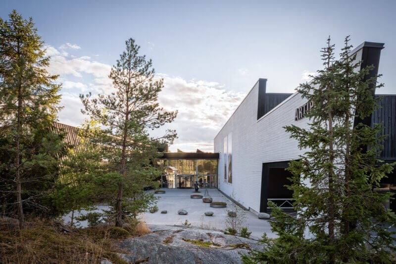 Inbäddat bland träd och klippor, har den moderna Om Artipelag-byggnaden en fantastisk glasentré som reflekterar den klara himlen ovanför.