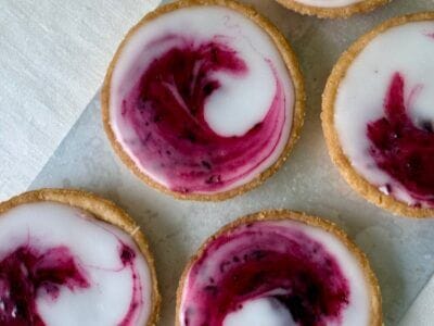 Bakverket saffranskatalaner med svartvinbärssylt uppradade på ett fat