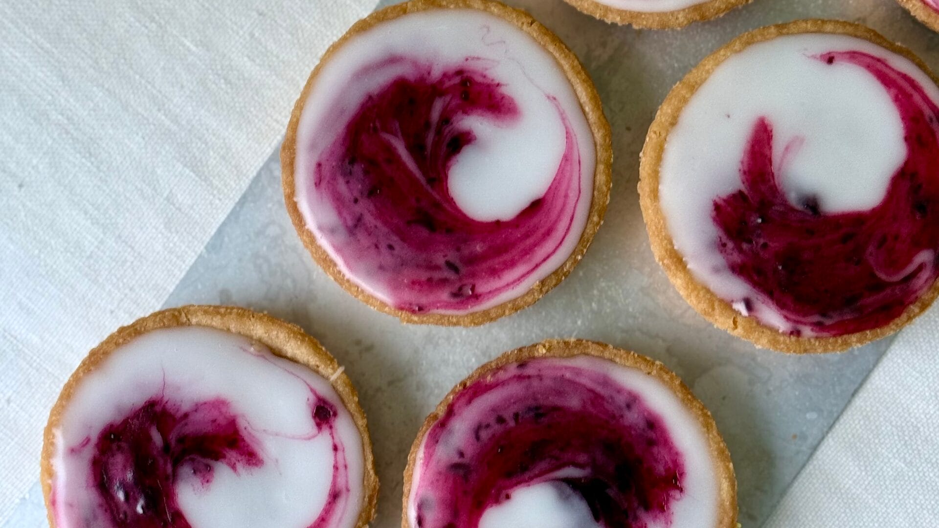 Bakverket saffranskatalaner med svartvinbärssylt uppradade på ett fat