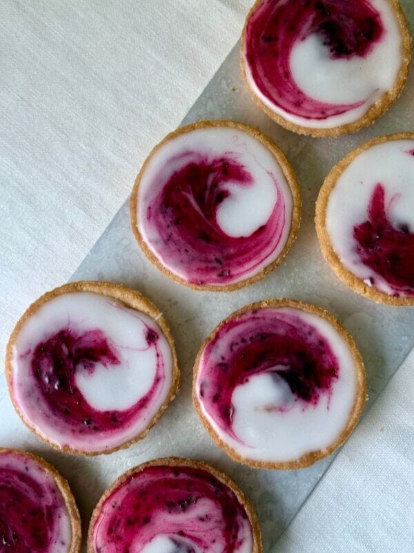 Bakverket saffranskatalaner med svartvinbärssylt uppradade på ett fat