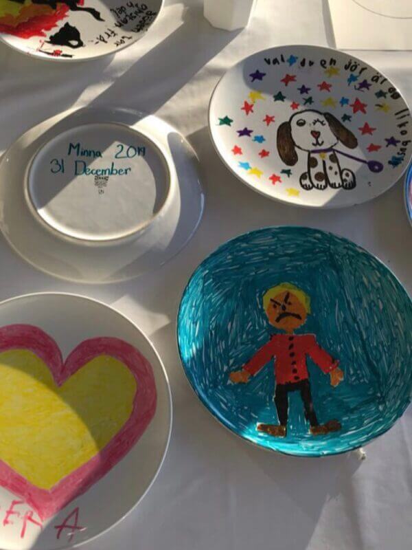 Egenmålade tallrikar som är utplacerade på ett bord.