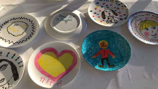 Egenmålade tallrikar som är utplacerade på ett bord.