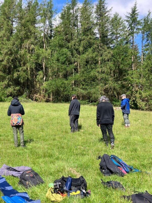 Människor som står på en äng.